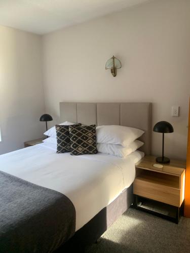 纳尔逊阿派斯汽车旅馆的一间卧室配有一张带两盏灯的大型白色床。