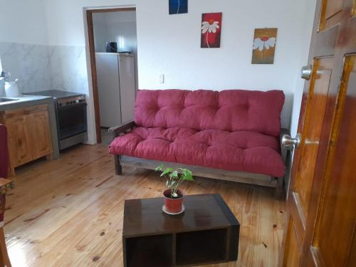 图蓬加托火山Mirador de Estrellas的客厅里一张红色的沙发,配有桌子