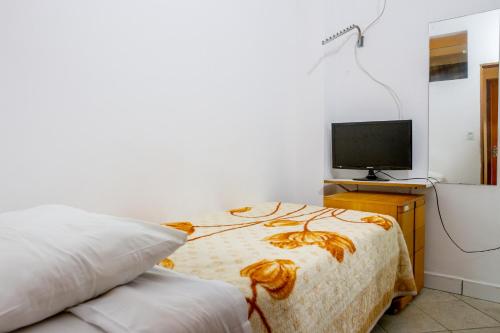 圣保罗Hotel Pousada Perdizes的一间卧室配有一张床和电视
