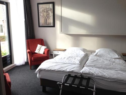 MolkwerumDe Rede的一间卧室配有一张床和一张红色椅子