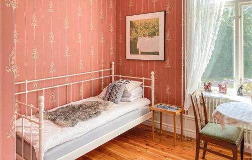 林德斯贝里Amazing Home In Lindesberg With House Sea View的一间设有床铺的卧室,位于一个红色墙壁的房间