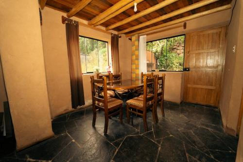 乌鲁班巴Casa cabaña privada en el Valle Sagrado Urubamba的一间带桌椅和窗户的用餐室