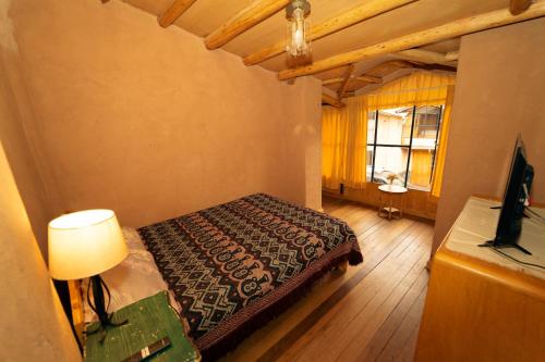 乌鲁班巴Casa cabaña privada en el Valle Sagrado Urubamba的一间卧室配有床、灯和窗户