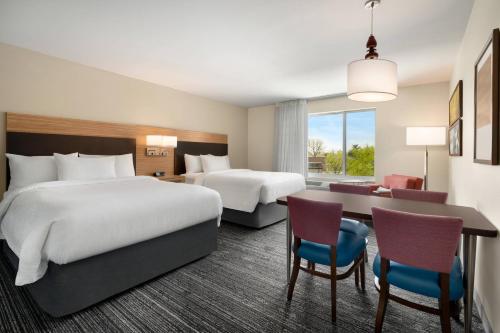 洛根TownePlace Suites by Marriott Logan的酒店客房配有两张床和一张书桌