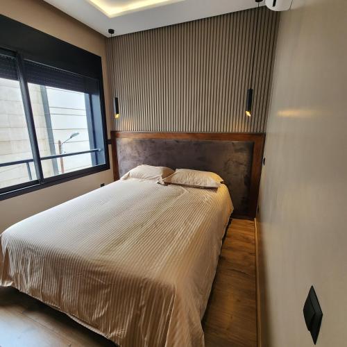 卡萨布兰卡Cosy Place的一间卧室设有一张床和一个大窗户