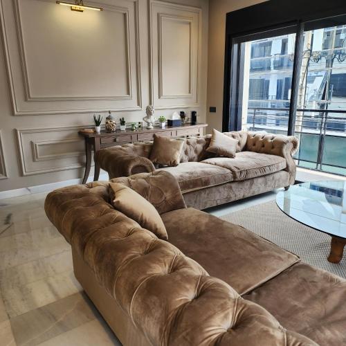卡萨布兰卡Cosy Place的客厅配有2张棕色沙发和1张桌子