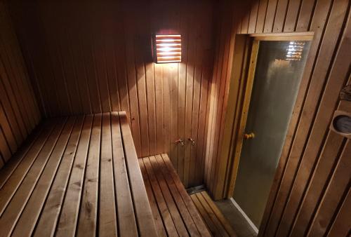 尤尔马拉Kemeri Roomstay & Sauna的墙上有灯的空木房
