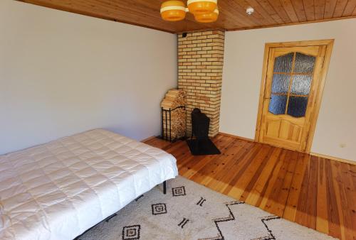 尤尔马拉Kemeri Roomstay & Sauna的一间卧室配有一张床,铺有木地板