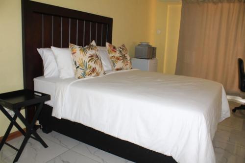 弗莱海德Kekeli B&B的卧室配有一张带白色床单和枕头的大床。