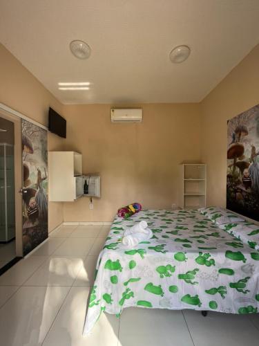 伊列乌斯Temporada Ilhéus Olivença的一间卧室配有一张带绿色棉被的床