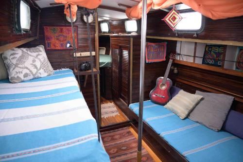El PorvenirSan Blas Sailing Experience With Us!的客房设有两张双层床和吉他。