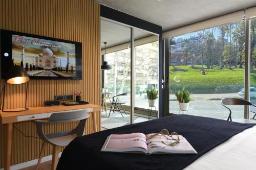蒙得维的亚Diseño con vistas al Parque y Mar Punta Carretas的一间卧室配有一张带书籍的床和一张书桌