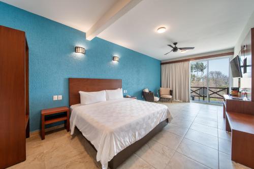圣克鲁斯华特库Villas Coral Huatulco的一间卧室设有一张床和蓝色的墙壁