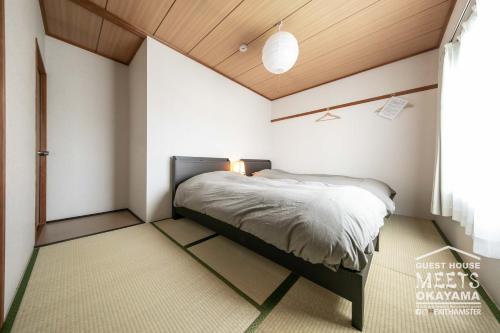冈山Guest House MEETS Okayama 全室個室のホステル的卧室配有一张床