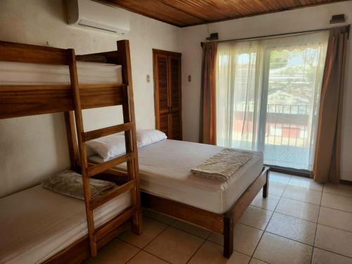 利比里亚Hostel El Pretal的一间卧室设有两张双层床和一扇窗户。