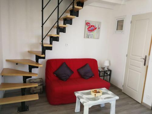 塔布palalain appartement的一间带红色沙发的客厅和楼梯