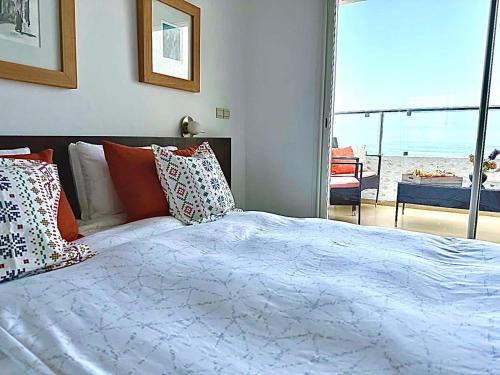 艾西拉Prestigieux Appartement à Marina Assilah Golf的一间卧室配有一张床,享有海滩美景