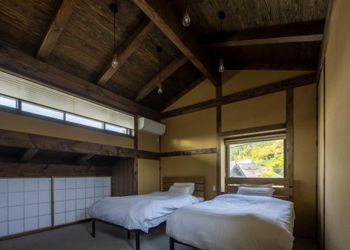 京丹后市casa網野的带窗户的客房内的两张床