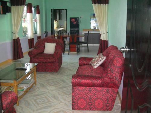 巴纳内拉斯ApartmenT - Homestays的客厅配有2把红色椅子和桌子
