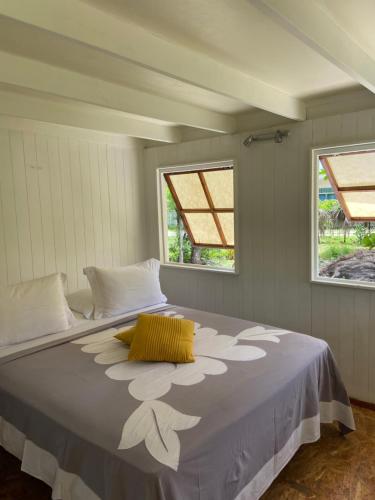 TemaeGreat House BY Manaeva Lodge的一张大床,位于带两个窗户的房间