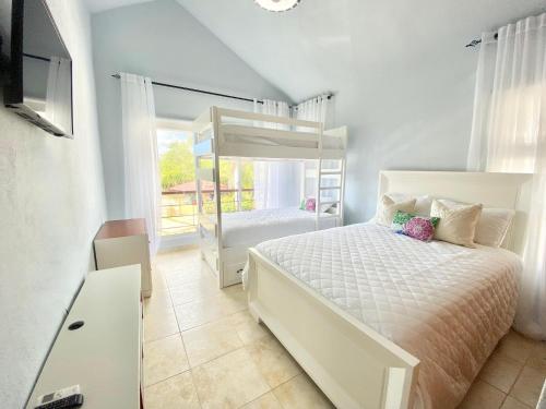 璜多里奥Bright Gorgeous Fully Equipped Villa W- Pool的卧室设有白色的床和大窗户