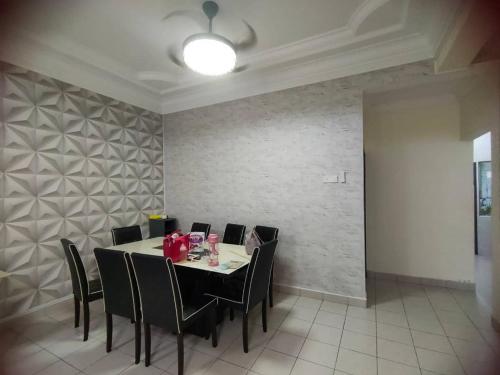 马西Happy Home [Bandar Seri Alam]的一间带桌子和黑色椅子的用餐室