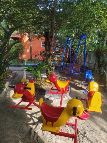 阿勒皮The Lake Paradise Boutique Resort的一个带五颜六色椅子和秋千的游乐场