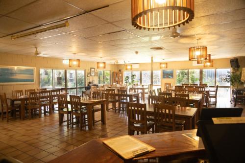 霍恩望盖海滩酒店的餐厅设有木桌、椅子和窗户。