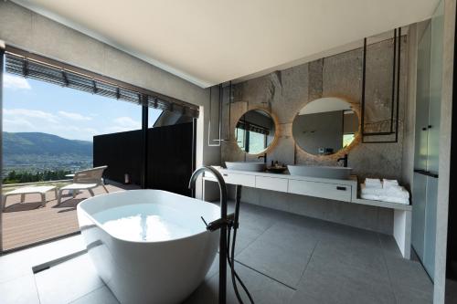 由布市ENOWA的浴室配有两个盥洗盆和浴缸。