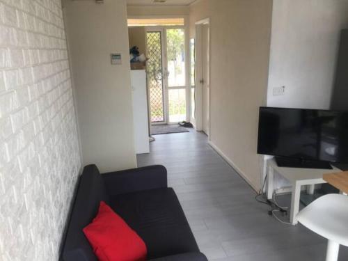 堪培拉Private Room in a Shared House-Close to City & ANU-2的客厅配有带红色枕头的黑色沙发