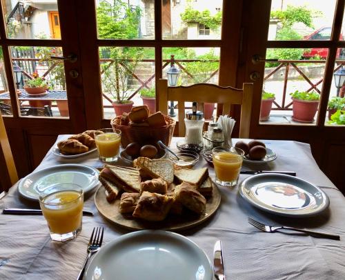 美特索文Apostolos Hotel的餐桌,带食物盘和橙汁杯