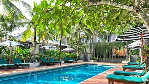 查龙Signature Phuket Resort的一个带躺椅和遮阳伞的游泳池