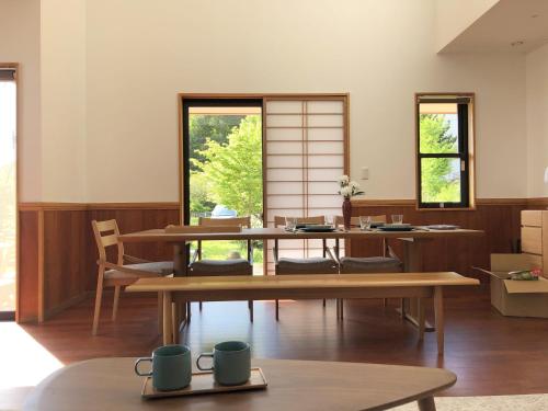 山梨市LiveGRACE Villa Lake Kawaguchiko 富士河口湖的客房设有桌椅和窗户。