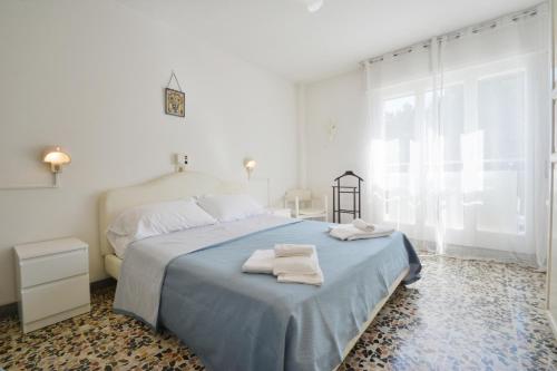马里纳－迪拉文纳Hotel Maddalena的白色卧室,配有带毛巾的床