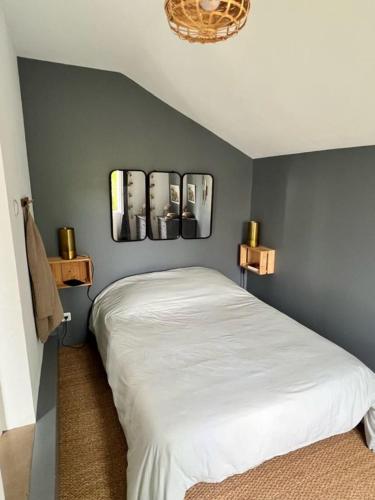 安德诺莱斯贝恩La maison du Mauret的卧室配有一张床,墙上有三幅照片