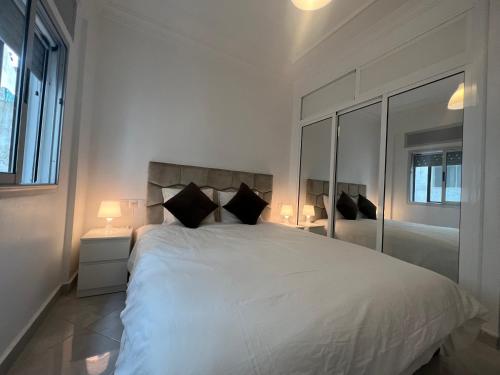 丹吉尔Tanger SABOR Central Aparts Fibre -ONLY FAMILY的白色卧室配有一张大床和两盏灯。