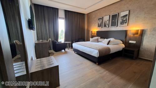 梅克内斯Hotel Jaouharat Ismaili的酒店客房配有一张床铺和一张桌子。
