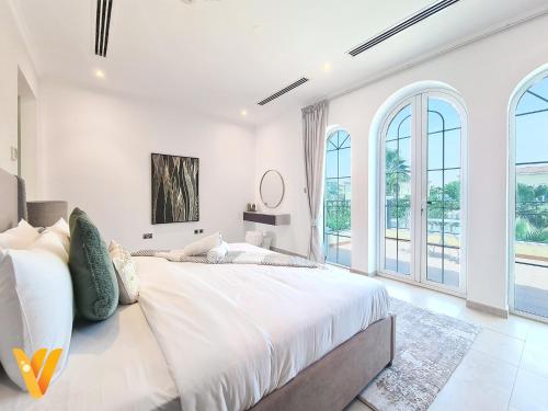 迪拜Luxury 3BR Private Villa and Elaborate Gardens的白色卧室设有大床和大窗户