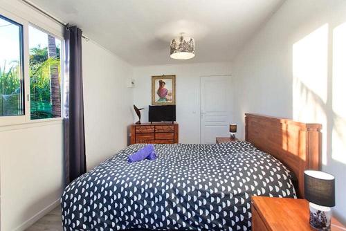 圣若瑟L'escapade créole Jacuzzi Privatif Bungalow Vanille的一间卧室配有一张带紫色枕头的床