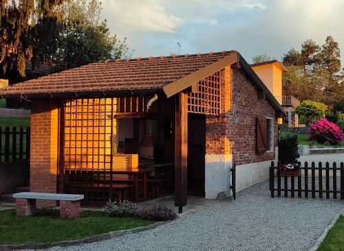 DivignanoCountry Corner Lago Maggiore的一座小砖砌建筑,在院子里设有长凳