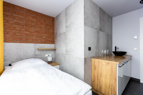 Hostel Dzika Kaczka的一间卧室设有一张床和砖墙
