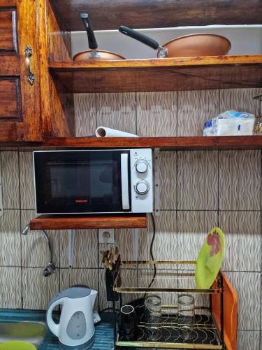 NkongsambaLa Cité des Anges的厨房台面上的一个微波炉