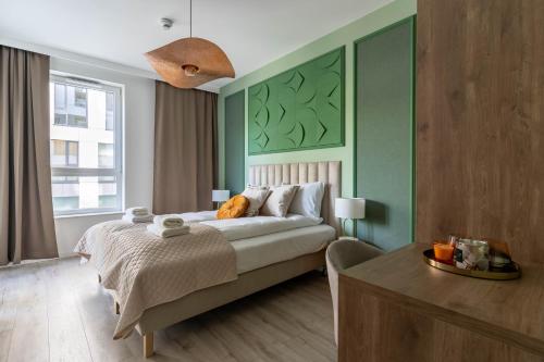 格丁尼亚Symphony Modern Tower Aparthotel的一间卧室设有一张带绿色墙壁的大床