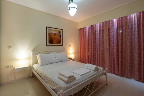 阿哈奈Glamour beautique villa的一间卧室配有床和红色窗帘的窗户