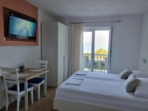 布雷拉Guesthouse Dominović的一间卧室配有一张床、一张桌子和一台电视