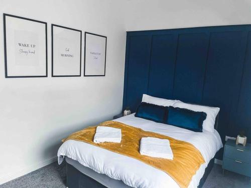 FarnworthComfortable Home In Bolton的蓝色和白色的卧室配有带两个枕头的床