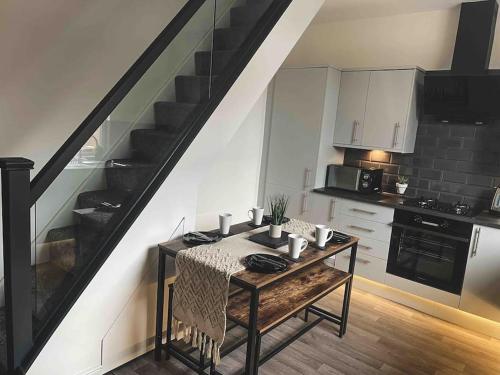 FarnworthComfortable Home In Bolton的一个带桌子和楼梯的小厨房
