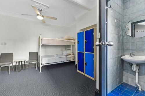 悉尼London Plane Backpackers的客房设有带水槽和镜子的浴室