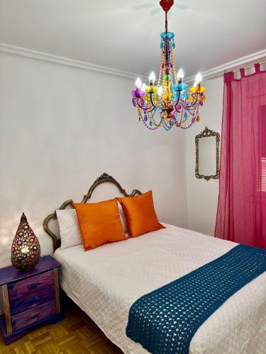 洛格罗尼奥Apartamento a 10 minutos de la Calle Laurel的一间卧室配有一张床和一个吊灯