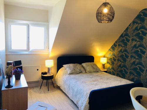 勒芒Au pied du circuit des 24h, chez Céline的一间卧室配有一张带两盏灯的床。